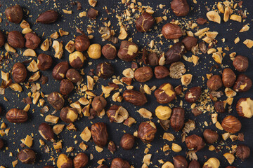 Background image of roasted hazelnuts isolated on the dark background. Roasted Hazelnuts.