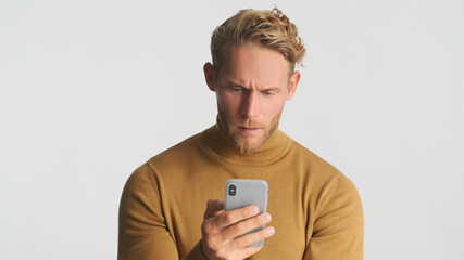 Serious bearded man wear turtleneck using smartphone for online communication checking business...