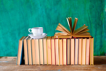 Row of books, an open book and cup of coffee. Reading,literature,education,library,home office...