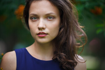 Girl in a blue dress walks in the park