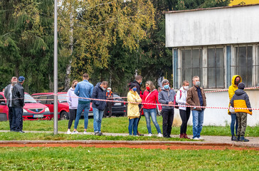 People in face masks waiting in front of checkpoint for testing for the coronavirus COVID-19