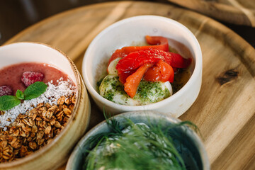 Healthy breakfast of cereals and strawberries on a tray and other food
