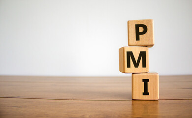 Concept word 'PMI - purchasing manager index' on cubes on a beautiful wooden table. White background. Business concept. Copy space.