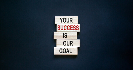 Wooden blocks with text 'your success is our goal'. Beautiful black background, copy space....