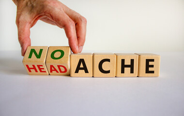 Male hand flips wooden cubes and changes the inscription 'head ache' to 'no ache'. Beautiful white background, copy space. Medical concept.