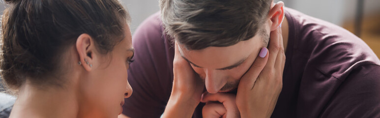 Fototapeta premium young woman touching head of depressed man, banner