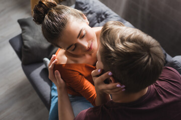 overhead view of man embracing smiling girlfriend touching his head