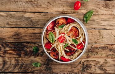 Italian pasta with chicken meatballs, tomatoes and basil.