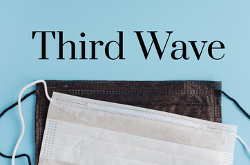 text third wave on a blue background with respiratory protective face masks