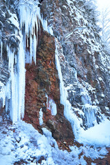 Fototapeta na wymiar Icicles on the rock. Frozen waterfall in winter.