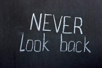 
Text on a dark board Never look back. Motivational lettering