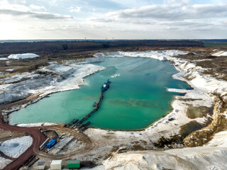 Aerial photo of one of the quartz quartz quartz quarry mining ponds with a suction dredger in the...