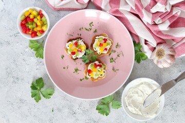 Canape or crostini with toasted bread, light cheese and colorful bell pepper. Top view with copy space.
