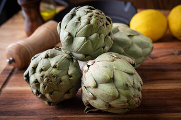 Obraz premium artichoke on wooden board at kitchen