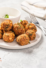 Homemade falafel close up. Chickpea balls with spices and yogurt with herbs on a gray concrete table.