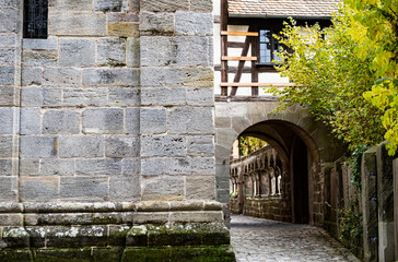 Timber frame & old stone church with arch walkway and cobblestone street. Taken in autumn / fall in Feuchtwangen, Germany