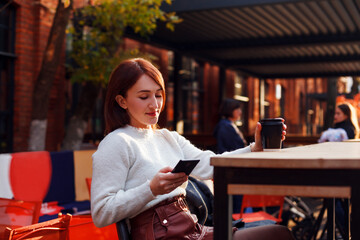 Online dating concept. Smiling young woman reading message from her smartphone.