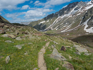 Summer view of alpine mountain valley with Stubai hiking trail, Stubai Hohenweg, rock, boulders and river stream. Tyrol Alps, Austria