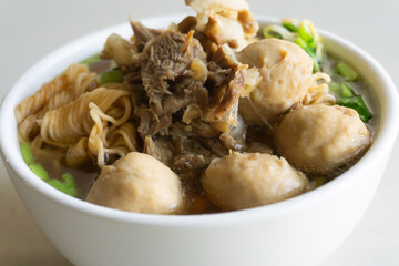 Thai Noodle (Tom Yum Noodles) has beef, meatballs, Ipomoea aquatica, Bean sprouts, in white bowl isolated on white background.