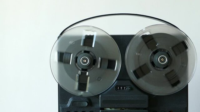 Black reel to reel tape recorder. Rotating retro tape. Vintage music player close up. Spinning reels transparent. Counter counts down record. Copy space. 4K 2160p 25fps Apple ProRes 422 HQ video.