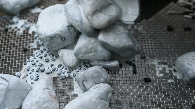 water rinse of final stage of rock tumbler over a metal screen.  