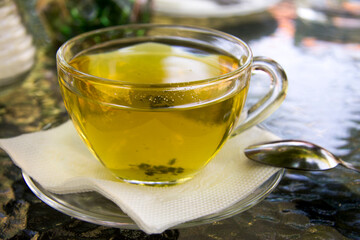 Cup of herbal tea in transparent cup outdoors