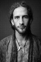 Young handsome Hispanic man with dreadlocks in black and white