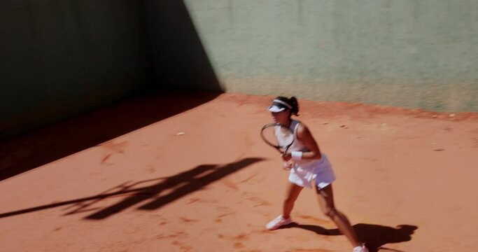Adult woman playing professional tennis on clay court