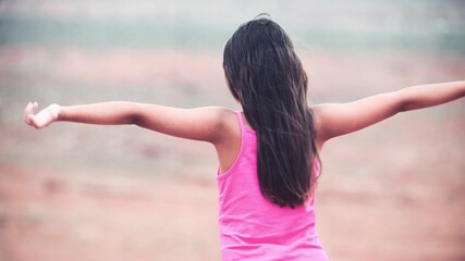 Young girl win open arms looking at panorama in national park