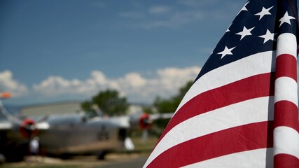 American flag waving to the wind with old airplane in the background