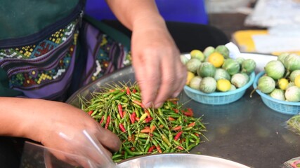 Woman cutting red chili in a city market
