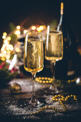 Champagne glasses and christmas decor on sparkling holiday background