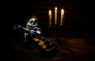 Gloomy night with still life of skeleton books candelabra and a violin
