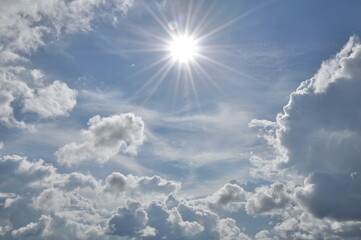 Blue skies with beautiful clouds and rays from the sun shining.