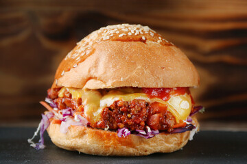 fresh tasty beef burger with cheese on wood background