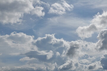 Blue skies with beautiful clouds and rays from the sun shining.