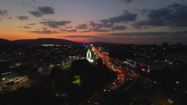Atardecer en ciudad con mucho trafico vista aerea