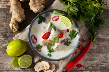 Traditional Thai food Tom Kha Gai and ingredients on wooden table. Top view