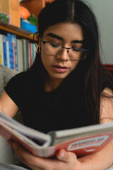 woman with glasses reading a book
