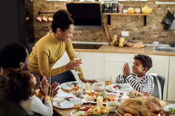 Fototapeta na wymiar Happy African American family enjoying in Christmas lunch at dining table.