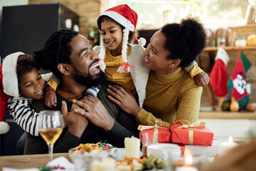 Joyful African American family having fun on Christmas day at home.