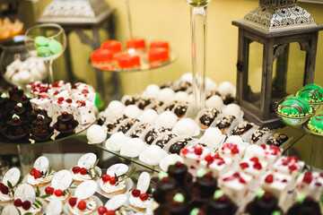 Delicious and tasty dessert table with cupcakes and shots at reception closeup