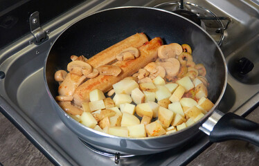 Vegetarian food is prepared on the gas stove in an old camper.