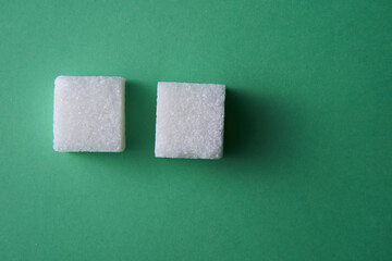 top view of white sugar cube on green background