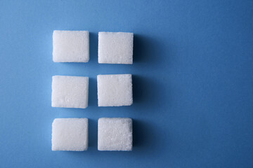 top view of white sugar cube on blue background