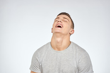 Fototapeta premium man in gray t-shirt emotions light background cropped view