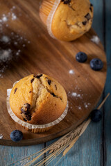 
Fresh muffins and blueberries on wooden cutting board