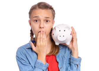 Beautiful teenage girl holds a piggy bank in her hands, isolated on white background