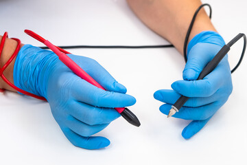 female hands in blue gloves hold a device for epilation
