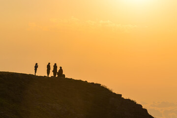 People silhouettes at sunset in the highlands